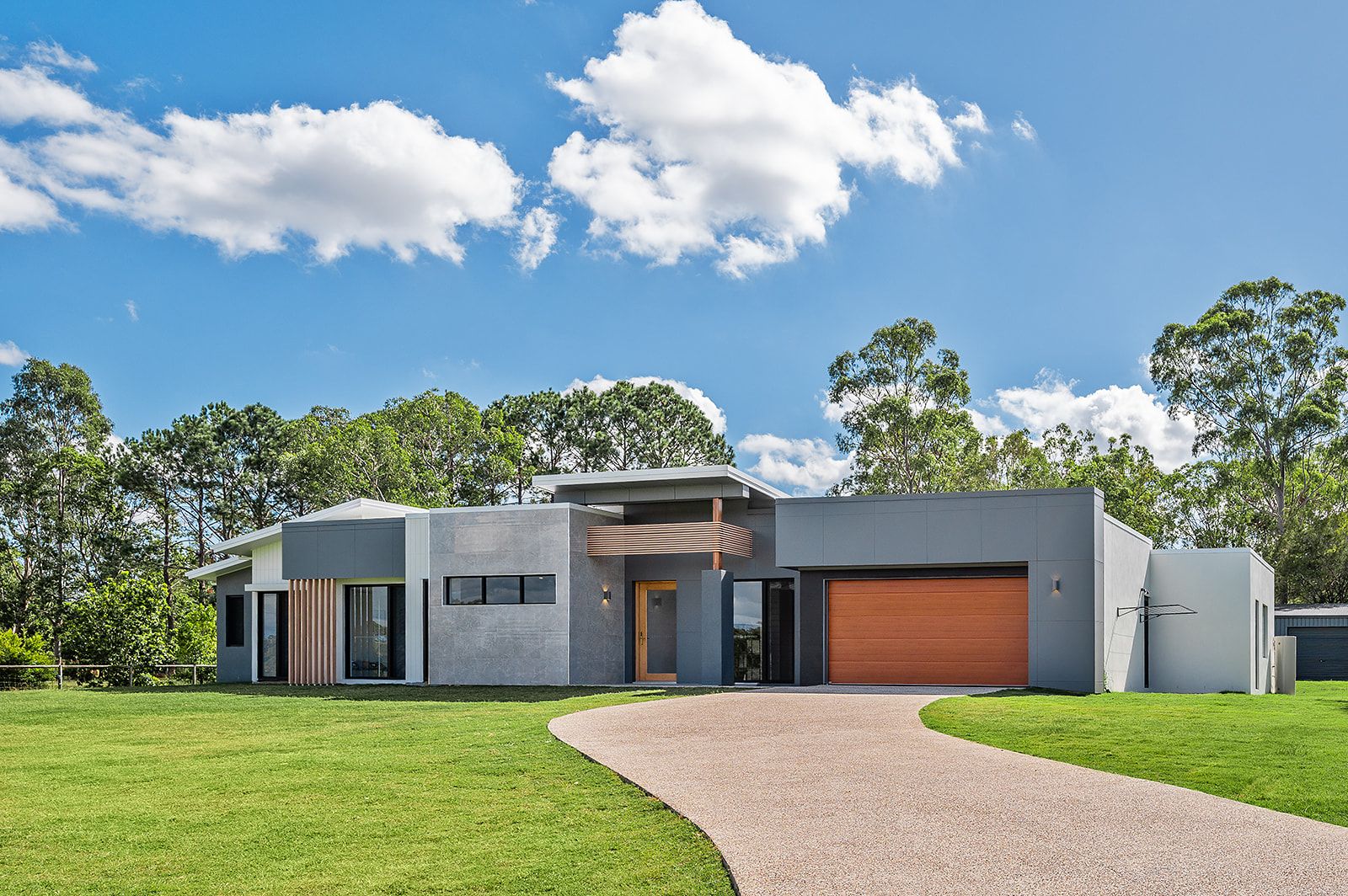 Front of a finished Fernbrook acreage home with a timber garage door