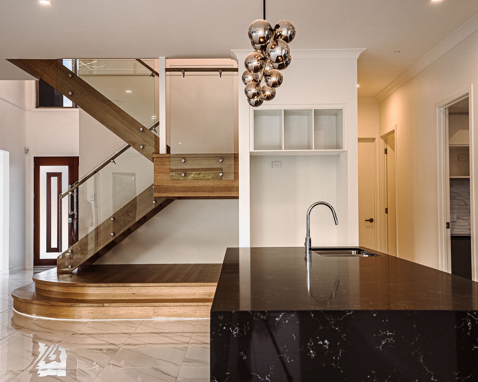 Floating timber staircase and stone kitchen island in a custom home